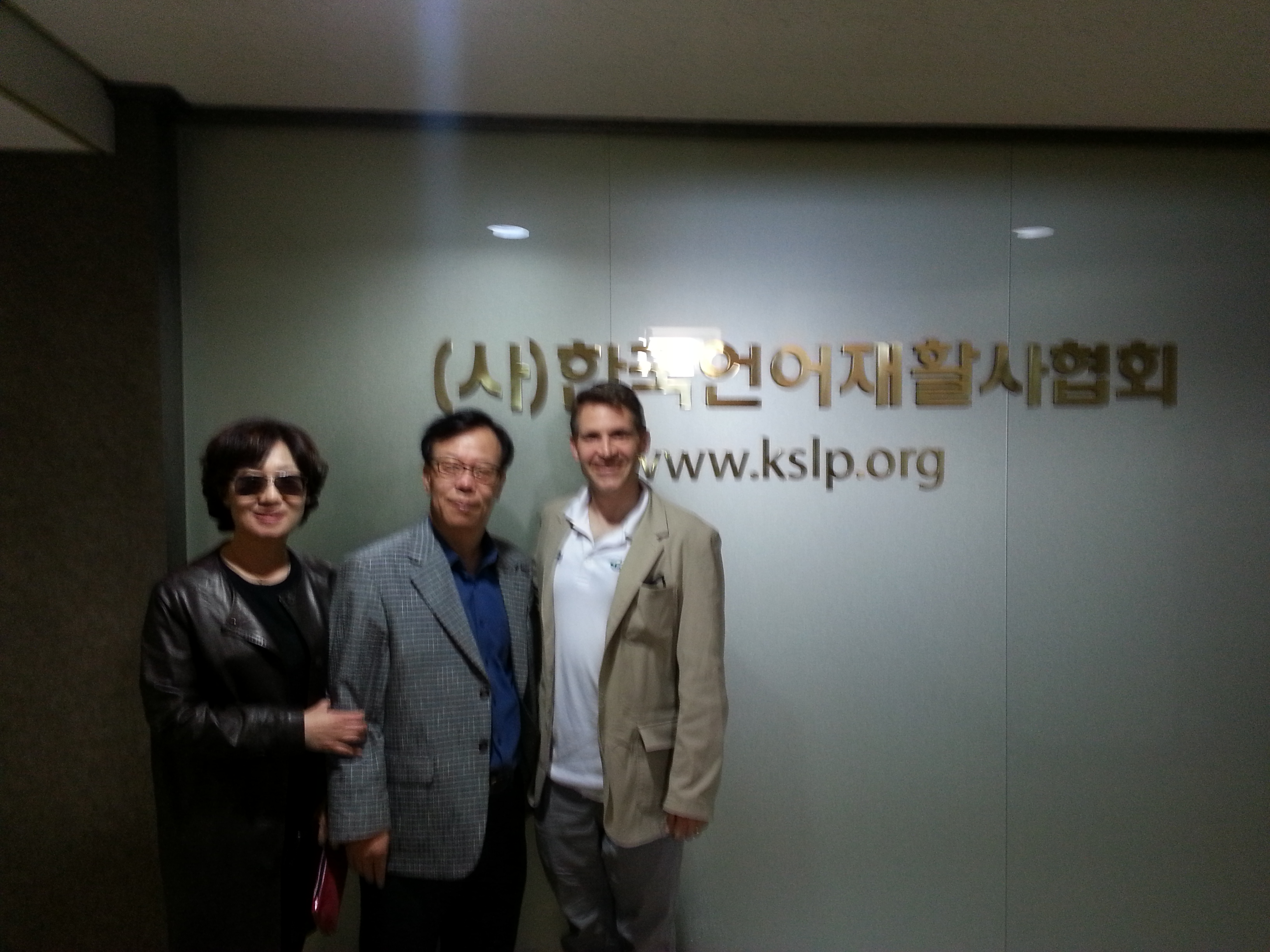 Photo of John McCarthy with Dr. Ko and his wife at KSLP offices